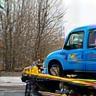 Tow truck lifting a compact car.